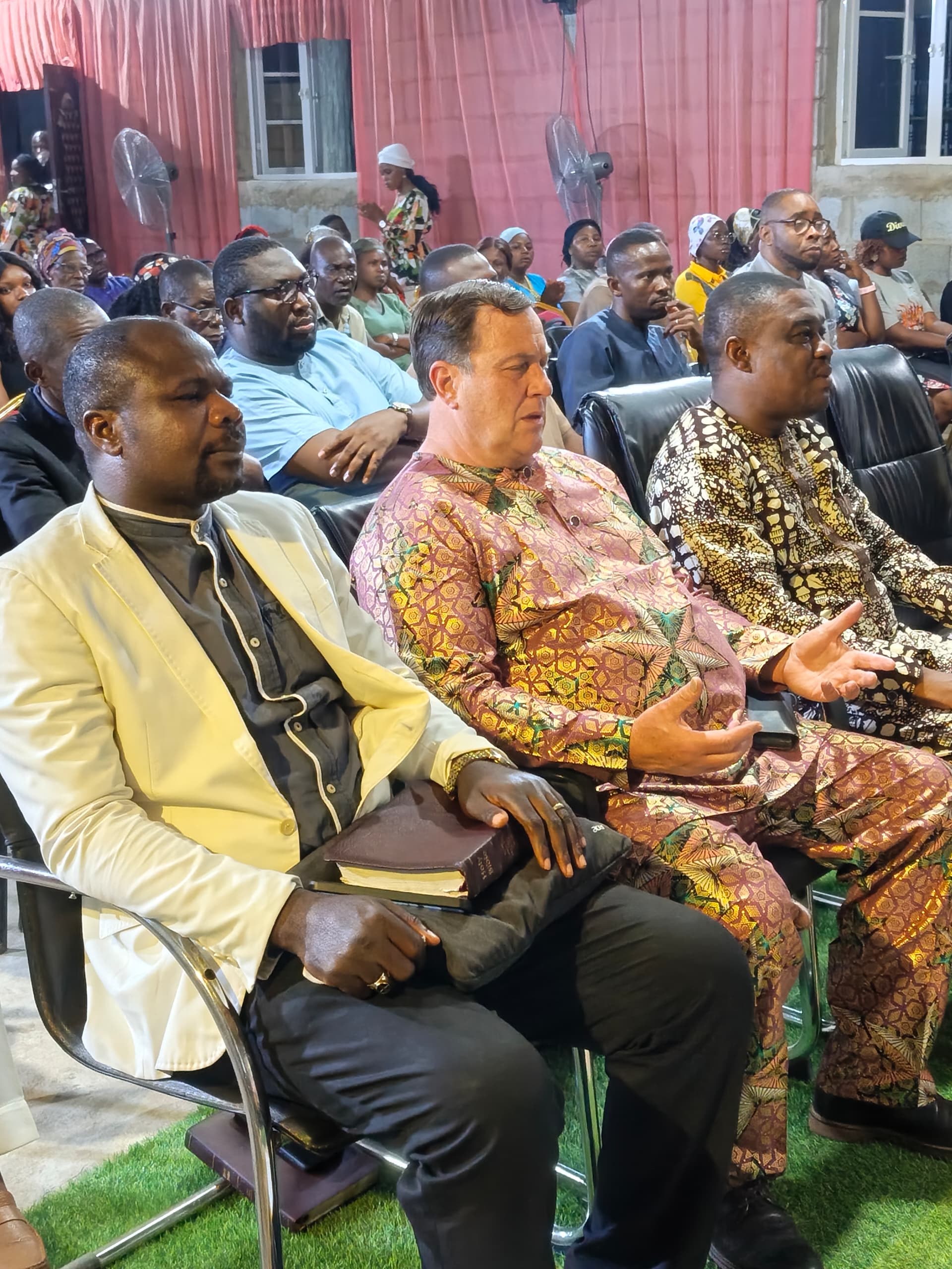 The TPIGC congregation gathered in worship with hands raised
